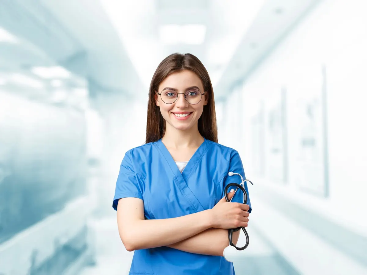 A smiling nurse in blue scrubs