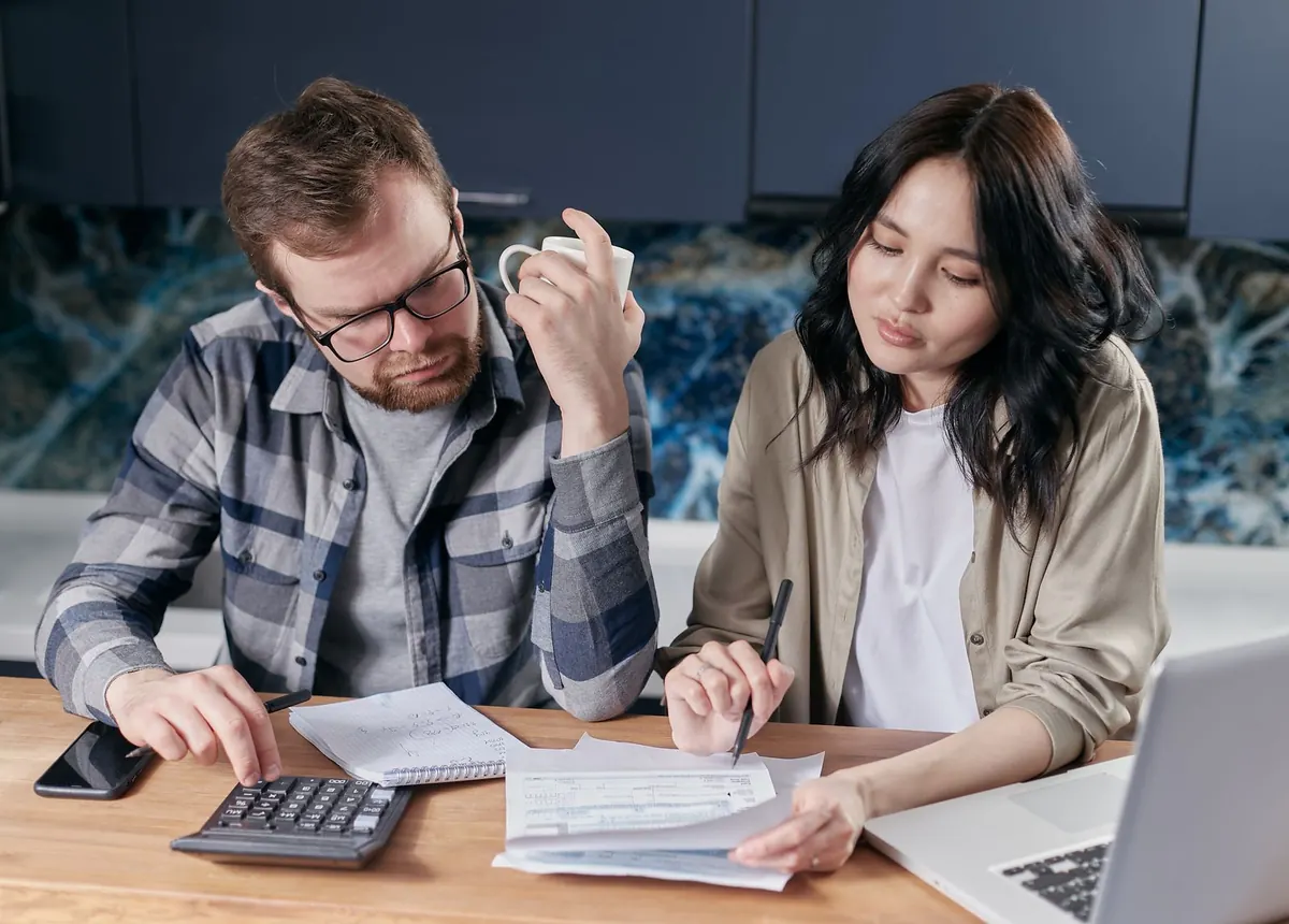A couple going through paperwork together at the kitchen table